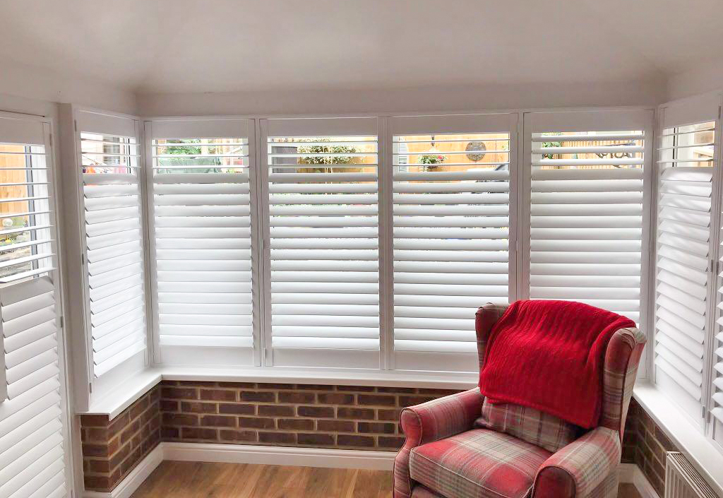 Shuttercraft-Winchester-Conservatory-Plantation-Shutters-with-Red-Chair