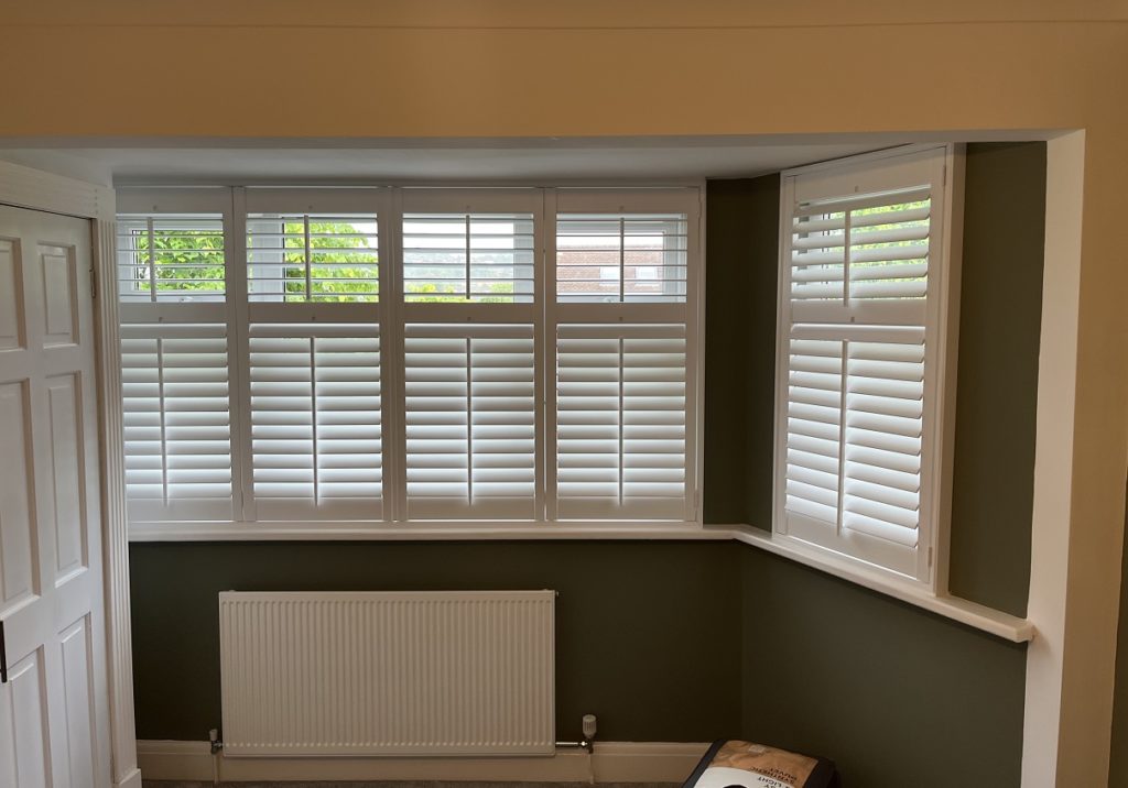 Stylish white wooden window shutters in Henley Bay
