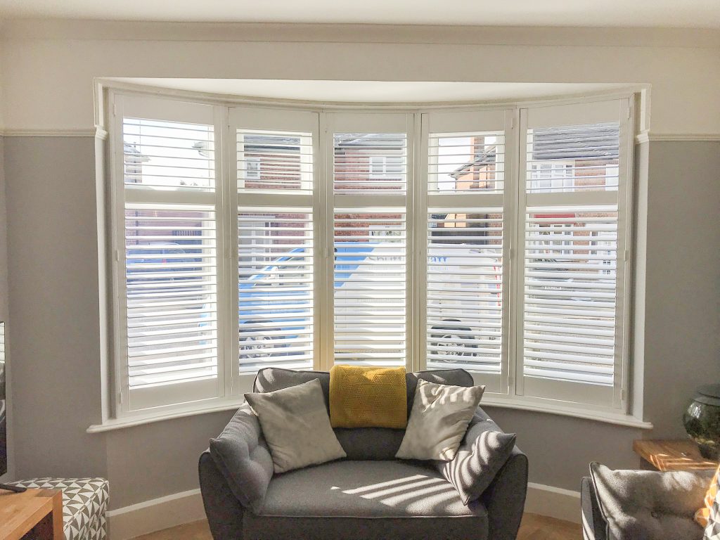 Full height white bay window shutters