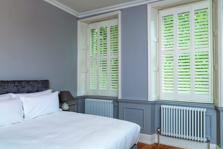 White wooden shutter blinds in a period bedroom