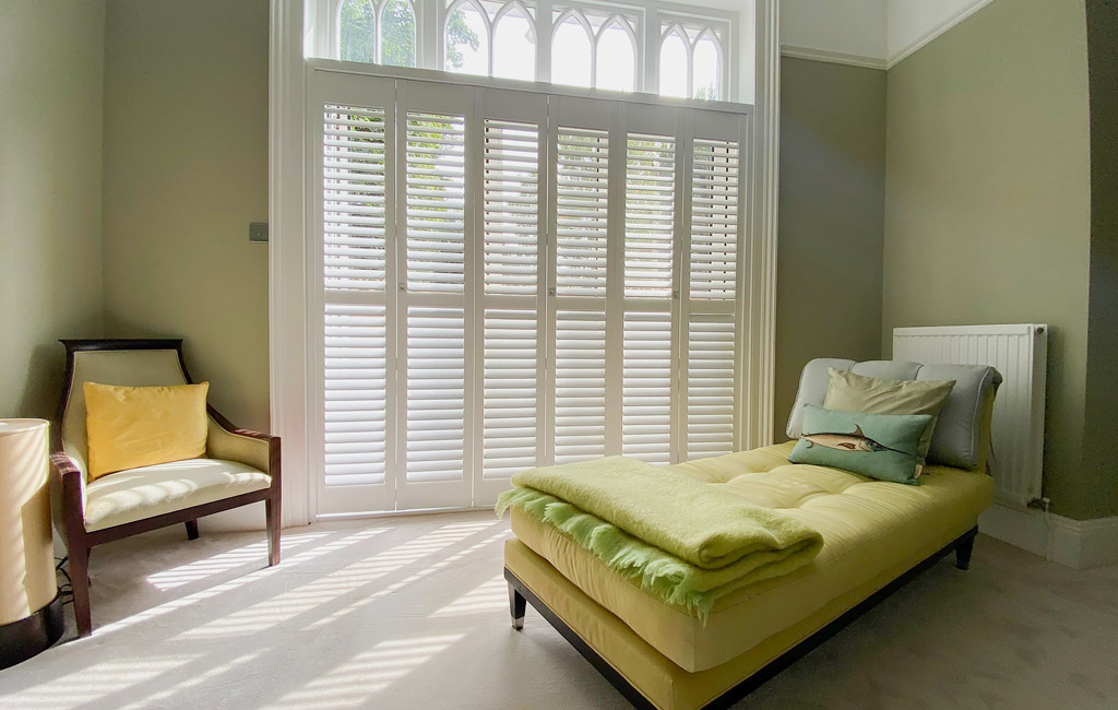 full height white shutters with green furniture
