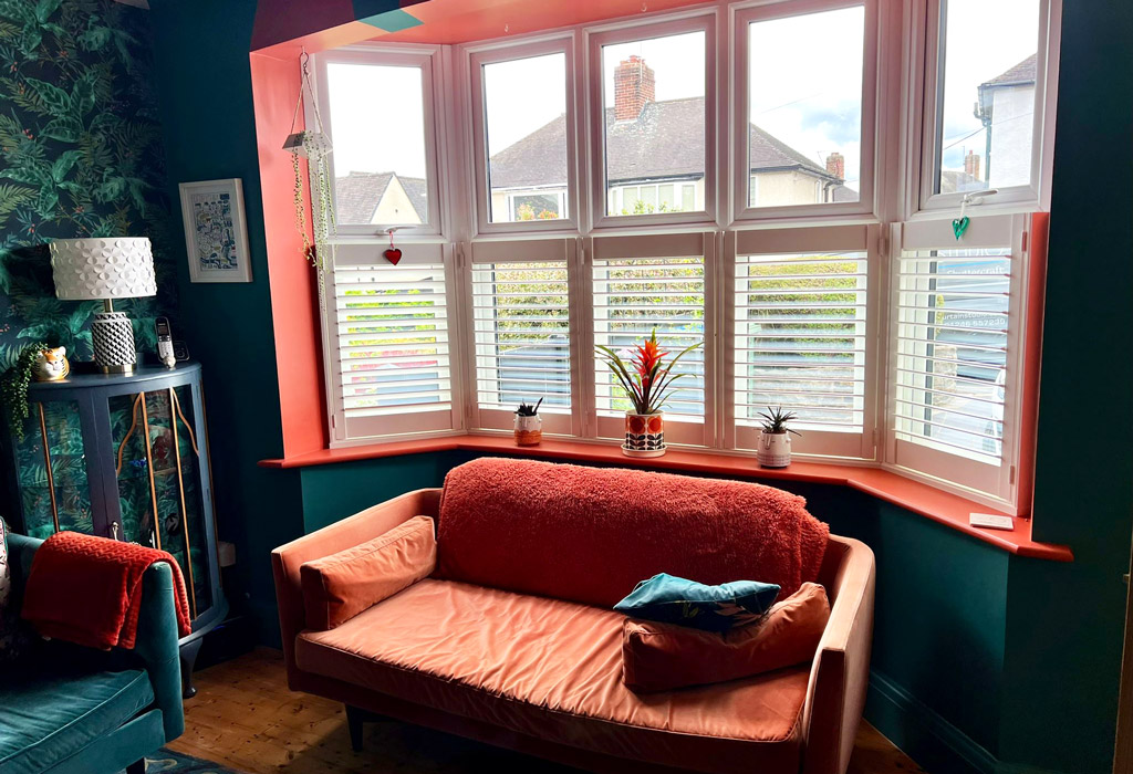 red and green living room with bay window cafe shutters