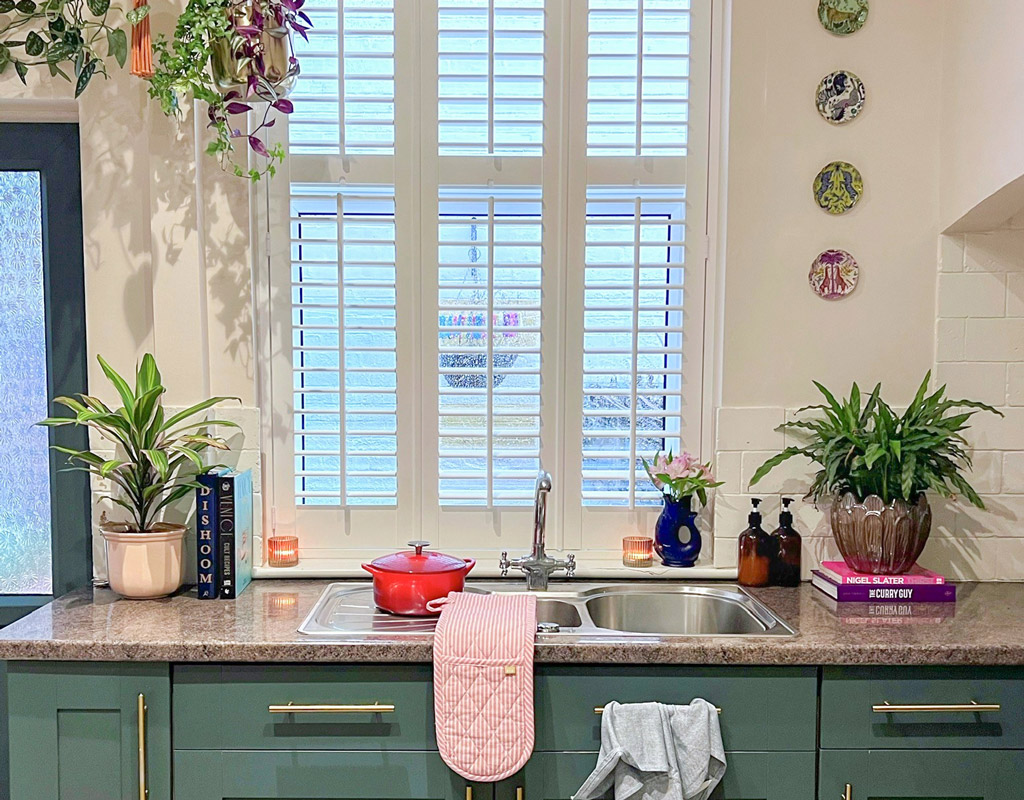 green kitchen with white shutters