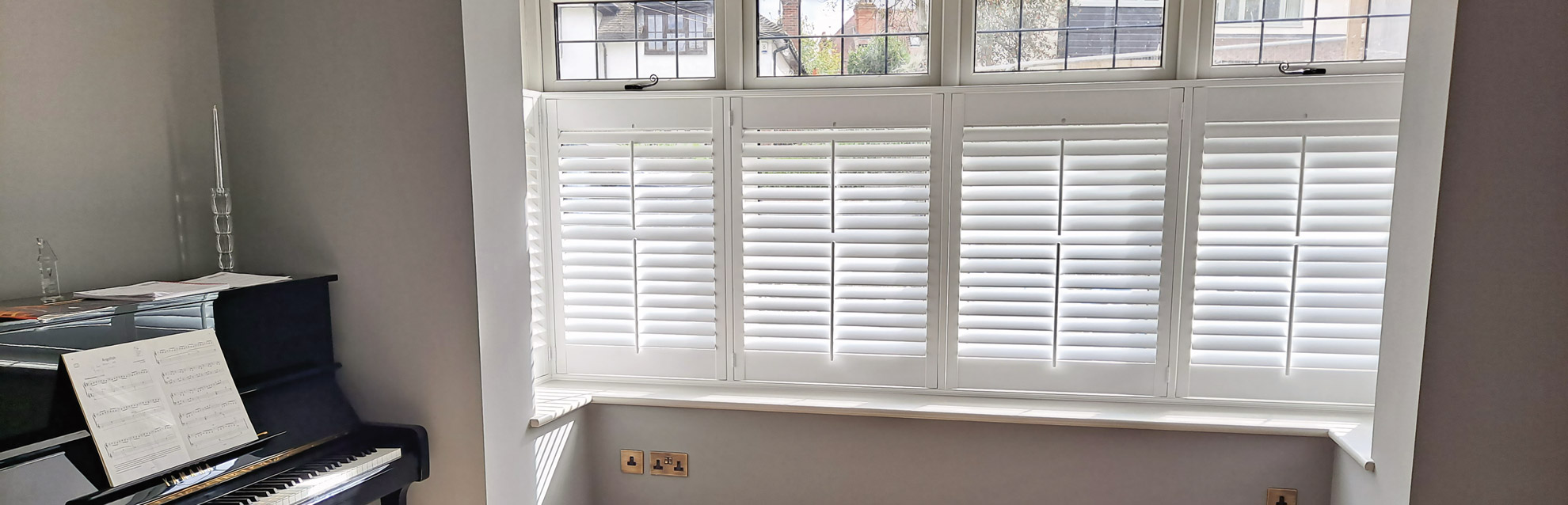 White cafe style shutters in piano room window