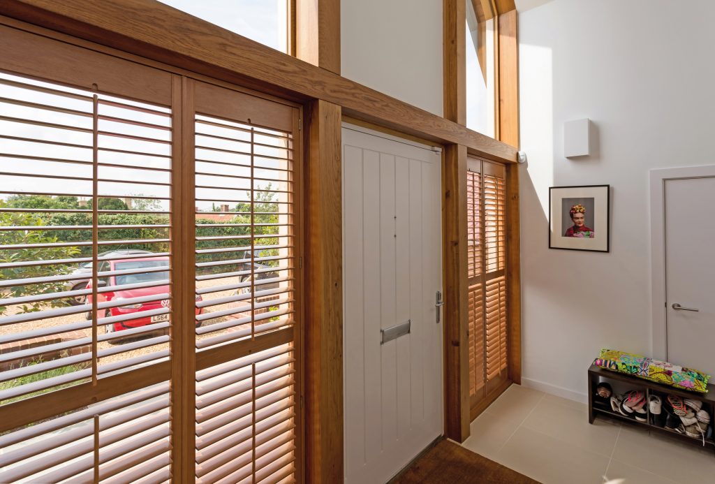 Natural wood shutters for insulation in large porch windows